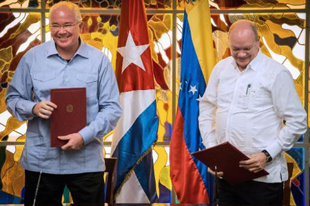 El canciller venezolano, Rafael Ramírez, y el ministro cubano de Comercio Exterior e Inversiones, Rodrigo Malmierca (D), dirman acuerdos de cooperación antes de la cumbre del ALBA. AFP / ADALBERTO ROQUE 