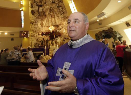 En esta foto tomada el jueves 18 de diciembre del 2014, el sacerdote Juan Rumín Domínguez habla con un reportero en la Ermita de la Caridad en Miami. AP / ALAN DIAZ