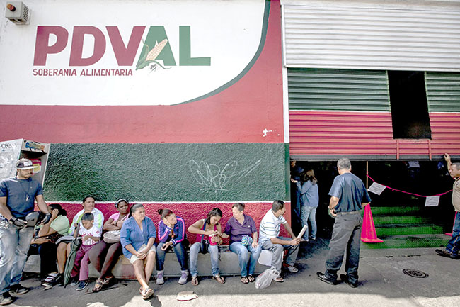 CAR02. CARACAS (VENEZUELA), 09/01/2015.- Un grupo de personas aguarda en la entrada de un supermercado Productora y Distribuidora Venezolana de Alimentos (PDVAL) hoy, viernes 9 de enero del 2015, en la ciudad de Caracas (Venezuela). El aÒo 2015 ha empezado en Venezuela con grandes colas en los supermercados en los que se sabe que ha llegado alg˙n producto de los que no hay suministro suficiente, como el detergente o los paÒales, ya que, tras dos aÒos de escasez, este mes de enero el problema ha alcanzado niveles crÌticos. EFE/MIGUEL GUTI…RREZ