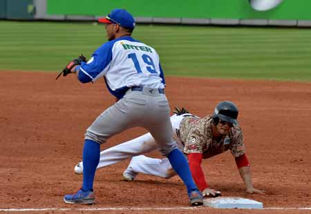 Infielder Neftali Soto of Puerto Rico makes an out on first base against Felix Perez of Venezuela during their 2016 Caribbean baseball series game on February 1, 2016 in Santo Domingo. AFP PHOTO/YAMIL LAGE / AFP / YAMIL LAGE