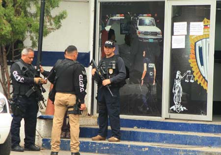 Funcionarios del Cicpc apostados a la puerta de la subdelegación del Valle, escenario del triple homicidio de detectives. LV / JL