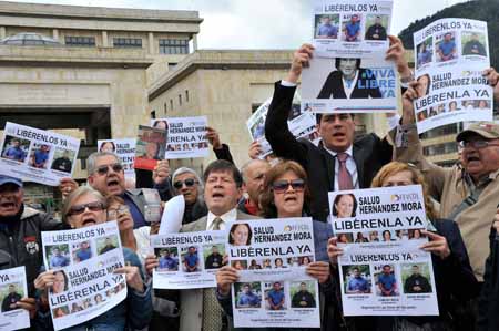 Residentes de Bogotá, junto a periodistas, reclamando con afiches la liberación de los tres secuestrados presuntamente a manos de la guerrilla del ELN. AFP / GUILLERMO LEGARIA