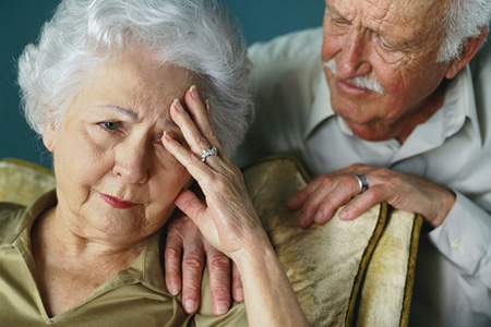 close-up of an elderly man consoling his wife