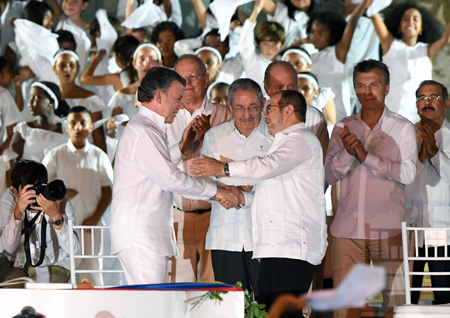 El presidente Juan Manuel Santos y el máximo líder de las Fuerzas Armadas Revolucionarias de Colombia (FARC), Rodrigo Londoño, estrechan sus manos luego de  firmar en Cartagena, el pacto alcanzado el 24 de agosto tras casi cuatro años de negociaciones en Cuba. LUIS ACOSTA / AFP 
