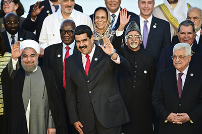 Iranian President Hassan Rouhani (L), Venezuelan President Nicolas Maduro (C) and Palestinian President Mahmoud Abbas (R) salute during the photo family in the Non-Aligned Movement summit in Porlamar, Margarita Island, Venezuela, on September 17, 2016. With the left increasingly isolated by a crushing political and economic crisis, Venezuela is seeking the support of old friends at the Non-Aligned Movement summit it is hosting this weekend. / AFP PHOTO / RONALDO SCHEMIDT