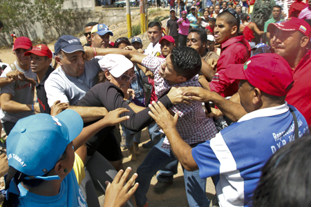 En el único incidente de la jornada, seguidores del gobierno se enfrentaron a golpes y empujones a opositores en la entrada de la comunidad Villa Rosa, en Margarita, cuyos vecinos sonaron cacerolas al mandatario hace un mes. AFP