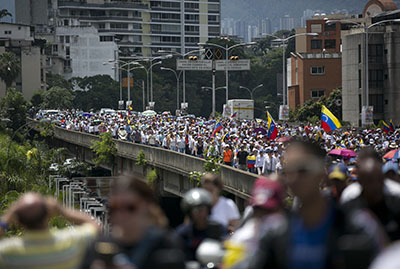 People protest along a main street to demand a recall referendum against Venezuela's President Nicolas Maduro in Caracas, Venezuela, Saturday, Oct. 22, 2016. Venezuela is bracing for turbulence after the government blocked a presidential recall referendum in a move opposition leaders are calling a coup. The march was led by the wives of jailed activists. (AP Photo/Ariana Cubillos)