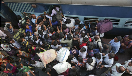 Decenas de pasajeros tratan de subirse a un tren en Hyderbad, India.